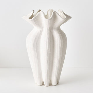 White ceramic vase with wavy design on a white background