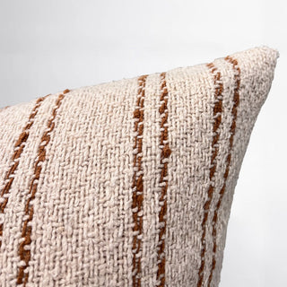 Textured pillow with brown stripes on a light gray background