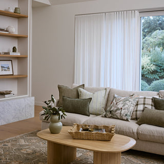 Living room with a beige sofa, wooden coffee table, and large window.