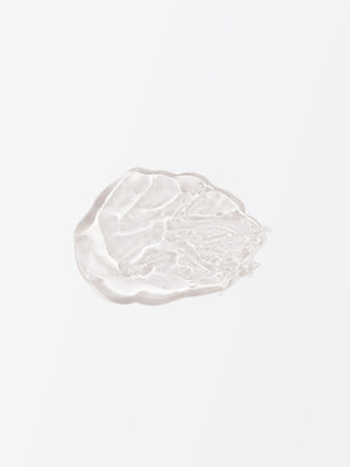 White cosmetic cream smear on a light gray background