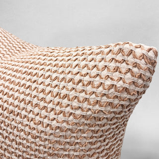 Textured pillow with a woven pattern on a light gray background