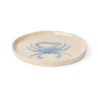 Round ceramic plate with a blue crab design on a white background