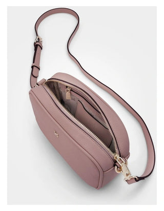 Pink crossbody bag with a strap on a light gray background