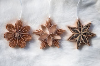 Three paper flowers made from brown paper on a white background