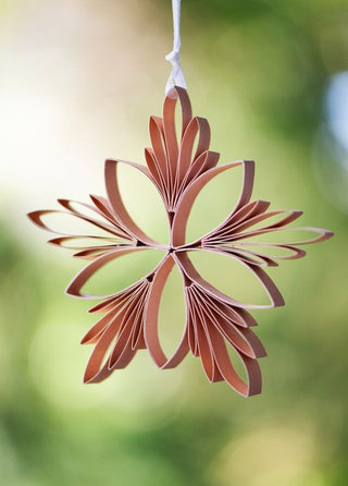 Decorative paper star hanging against a blurred green background