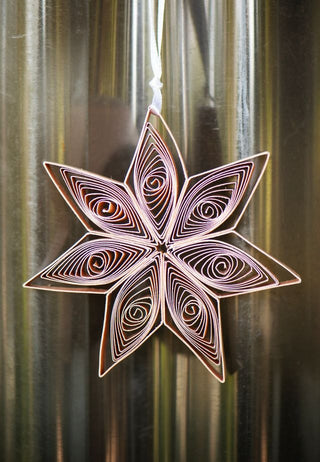 Decorative paper star hanging against a metallic background