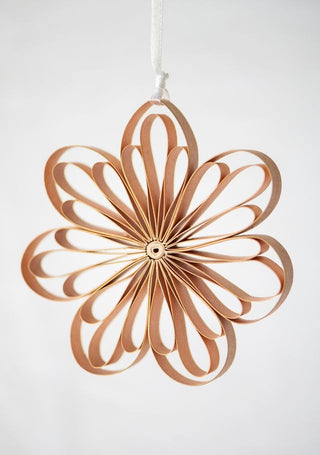 Decorative star-shaped object made of interlocking wooden rings on a white background