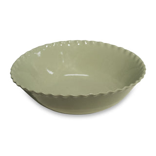 Green ceramic bowl with scalloped edge on a white background