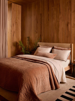 Bedroom with wooden wall and brown bedding