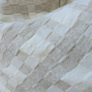 Close-up of textured beige fabric with diamond pattern