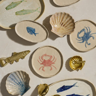 Collection of ceramic plates with sea-themed designs on a light background