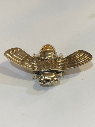 Gold bee-shaped decorative item on a white background