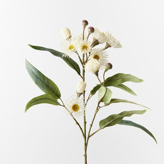 Artificial eucalyptus branch with white flowers and green leaves on a light gray background