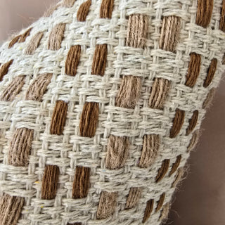 Close-up of a woven fabric with a grid pattern on a neutral background