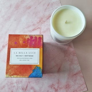 La Bella Luce candle and packaging on a pink marble surface