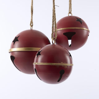 Three red spherical bells with black star patterns and gold bands hanging against a white background.