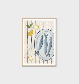 Framed artwork of a plate with fish, lemons, and a fork on a wooden background.