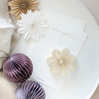 Decorative paper flowers and balls on a white surface