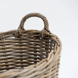 Close-up of a wicker basket with a handle on a light gray background