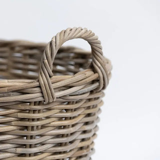 Close-up of a woven basket with a handle on a light background