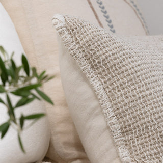 Textured pillow with a plant in the background