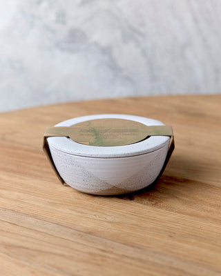 Round concrete object with a gold rim on a wooden surface