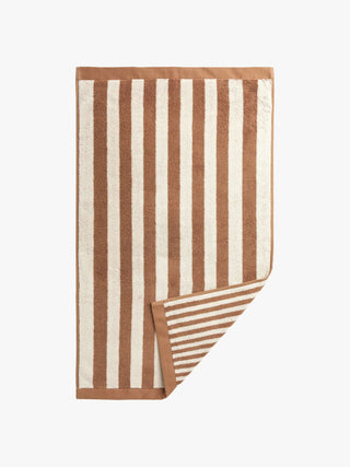 Striped towel with brown and white stripes on a white background
