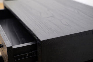 Close-up of a dark wooden desk corner with a drawer.