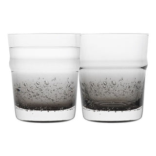 Two clear glasses with bubbles on a white background