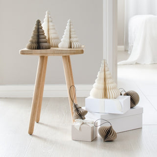 Wooden and paper Christmas trees on a white surface with a neutral background