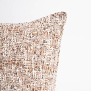 Textured pillow with a neutral color palette on a light background