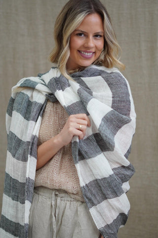 Woman wearing a plaid shawl over her shoulders against a neutral background