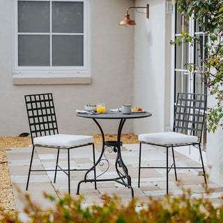Outdoor patio set with table and chairs on a patio area.