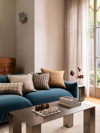 Modern living room with a blue sofa, coffee table, and decorative pillows.