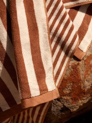 Brown and beige striped towel on a textured surface