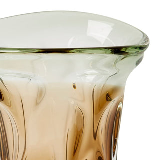 Close-up of a glass with a gradient color from green to brown on a white background