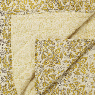 Clovelly Golden Quilt - Patterned fabric with mustard and black design on a beige background