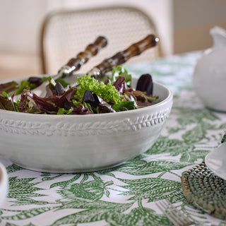 White bowl of salad on a patterned tablecloth with a blurred background
