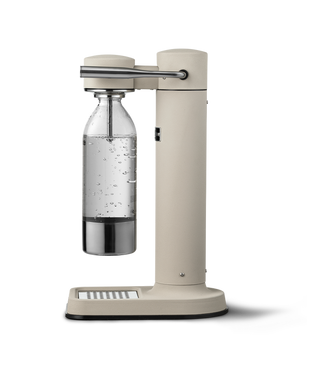 Beige carbonation machine with clear bottle on a white background