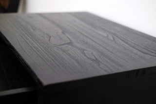 Close-up of a dark wooden surface with a blurred background