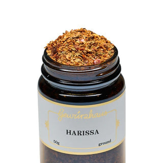 Jar of ground harissa spice with a visible brand name on a white background