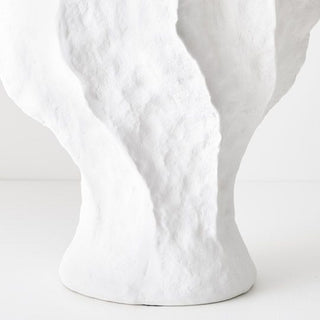 Close-up of a textured white vase on a light gray background