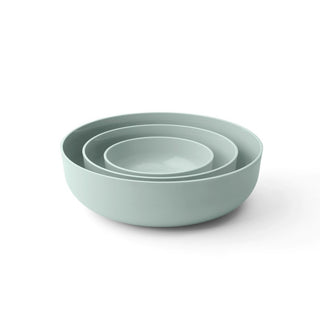 Set of three light green bowls stacked on a white background