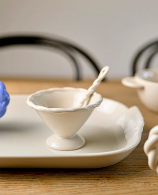 White ceramic dish with a small white bowl on a wooden table