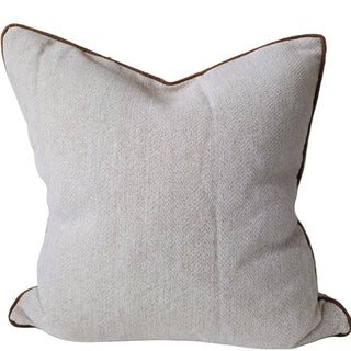 Textured pillow with brown trim on a white background