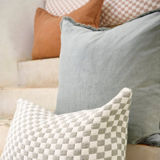 Close-up of various pillows on a sofa with a focus on texture and color.