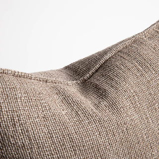 Close-up of a textured brown fabric surface with a visible seam.