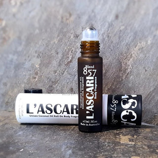 L'Ascaris roll-on body fragrance bottle and packaging on a stone surface