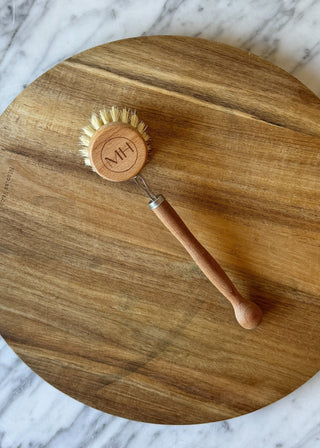 Wooden brush with a handle on a wooden surface