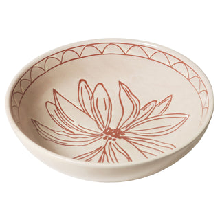 Ceramic bowl with red floral design on a beige background